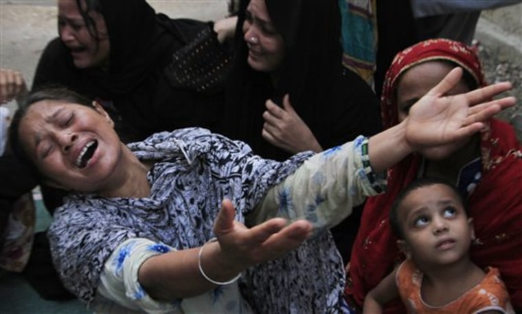 Family members of a slaying victim mourn his death in Karachi, Pakistan, on Wednesday, Aug. 17. At least 10 people died in the latest violence, including a former parliamentarian of the ruling party, police said. 